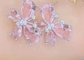 Pink gemstone flower stud earrings with crystal center petals shown on ear - White Gold Plated Pink Stone
