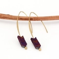 Detailed view of bohemian v-shape hematite arrow drop earrings hanging on a branch - Purple