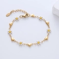 Detailed view of 18k gold plated stainless steel bracelet with daisy and heart charms - White Flower