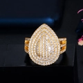 Eleganter goldener Tropfenring mit Zirkonia-Besatz und Pavé-Fassung auf dunklem Grund - Gold Wassertropfen Offener Ring