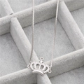 Macro di collana con pendente a corona d'argento e zirconi su vassoio di velluto grigio - Corona C (Platino/Zirconia Bianca) / Argento