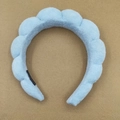 Detail of light blue towel fabric headband featuring a handmade label on a brown base - Light Blue Towel Cloth Braided