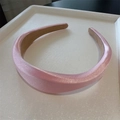 Primer plano de diadema acolchada de satén rosa con acabado brillante en bandeja - Rosa