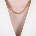 Collier doré minimaliste avec pendentifs perles roses et dorées sur un mannequin - Violet