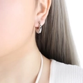 Silver croissant hoop earrings in polished titanium steel worn on model's ear - F857 / Silver