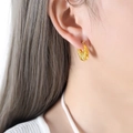 Gold hoop earrings featuring a minimalist spiral texture for women worn in a close-up profile - F857 / Gold