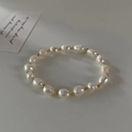 Detailed top view of baroque freshwater pearl bracelet with gold beads on leather background - Irregular Natural Pearl Bracelet