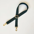 Détail d'une bandoulière en toile vert foncé avec boucle et crochets en métal doré - Vert