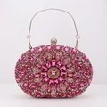 Makroaufnahme einer rosa Strass-Abendtasche mit Blumenmuster und goldener Kette - Rosarot