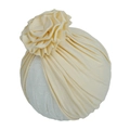 Détail d'un bonnet turban pour bébé jaune crème avec grande fleur et texture plissée - Beige