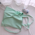 Dettaglio della borsa tote in tela verde menta con doppi manici in un ambiente minimalista - Stile a Tre Cinghie (Mano/Tracolla/Spalla) / Blu Acqua