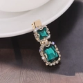 Fermaglio per capelli dorato con gemme verde smeraldo e strass su fondo scuro - Blu scuro