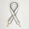 Close-up of cream canvas bag strap with black piping and gold adjustable buckles - White / Gold Hook