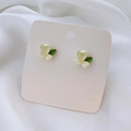 Detalle de pendientes de botón de tulipán con pétalos blancos y hojas verdes en tarjeta - Estilo Botón / Pendientes de botón de gardenia