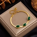 Elegant gold titanium necklace with emerald green geometric pendants on a velvet display - Green Gemstone Three Stones Style (B688)