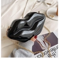 Detail view of glossy black lip-shaped clutch bag with detachable gold chain strap - Black