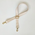 Detail of beige canvas bag strap with adjustable gold lobster clasps on white background - Off White