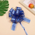 Detailed view of a handmade blue ribbon gift bow with gold edges and silk texture - Blue