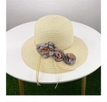 Close-up of beige straw sun hat featuring pink and grey fabric floral decorations - Beige