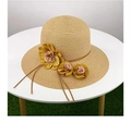 Detail of khaki straw sun hat with pink floral decoration on a white table - Khaki