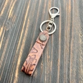 Vue détaillée du porte-clés en cuir marron embossé avec des finitions en métal argenté - Style 4 (Feuille Embossée)