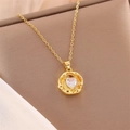 Close-up of heart-shaped zircon pendant on golden stainless steel chain over silk background - White