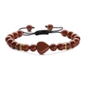 Detail of red sandstone heart pendant and beads on black braided adjustable bracelet - Gold Sandstone (Woven)