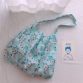 Gros plan détaillé du sac en toile bleu clair avec des motifs floraux pastel délicats - Bleu Clair Avec Des Fleurs Orange Rose