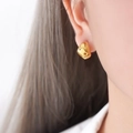 Pendientes de aro en C bañados en oro de 18K con grabado de estrella en la modelo - F100 Pendientes Dorados