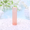 Empty 5g translucent pink plastic lip balm container with rotating base on white lace - Pink