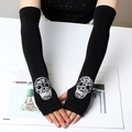 Black knitted arm sleeves featuring a rhinestone skull pattern on a model's hands - 40 (Long Style) / Black