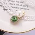 Elegante fermaglio dorato con gemma verde, perla e strass su sfondo di pizzo raffinato - Verde Chiaro G8105