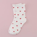 White cotton crew socks with red heart pattern and rolled edge on a pink background - All-over Hearts / White