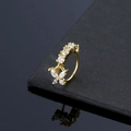 Golden butterfly nose ring with sparkling zircons displayed on a dark stone surface - Gold