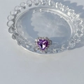 Macro d'une bague en argent avec une grande pierre violette en cœur et halo diamanté - Violet