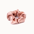Close-up of pink crystal satin scrunchie with smooth silk texture and ruched design - Rose Gold