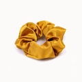 Close-up of golden silk satin hair scrunchie showing luxury fabric texture and pleats - Turmeric