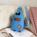 Dettaglio della borsa a tracolla in tela blu a forma di pinguino su una sedia beige - Blu