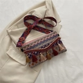 Detail einer gewebten Boho-Handtasche mit bunten Mustern und langen Fransenanhängern - Rosarot