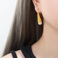 Eleganti orecchini a goccia oro e bianco indossati per un look moderno e minimalista - Oro