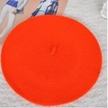 Detailed top view of bright orange wool beret hat placed on a white lace background - M / Orange Red