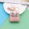 Detailed macro of pink PU leather owl coin purse keychain with soft tassel and gold hardware - Pink