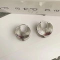 Detalle macro de pendientes geométricos plateados con diseño de media luna texturizada en capas - Plateado