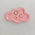 Detailaufnahme von Goldring und Ohrmanschetten auf rosa wolkenförmiger Schmuckschale - Rosa Wolke