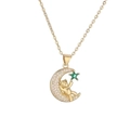 Dettaglio di un ciondolo a luna dorata con un orsetto e una gemma verde a forma di stella - Verde