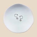 Macro view of silver butterfly nipple rings with zircon on a white ceramic tray - Butterfly Zirconia Pendant (23071924)