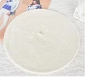Flat lay of a white wool beret hat for children on elegant lace background fabric - M / White