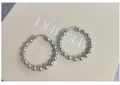 Macro detail of silver beaded hoop earrings featuring a polished mirror-like metallic finish - Beaded Hoop Style / Silver
