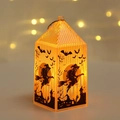Close-up of glowing orange Halloween lantern with black witch and bat silhouettes - Witch