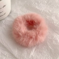 Nahaufnahme von weichem rosa Plüsch-Haargummi mit flauschiger Textur auf weißem Papier - Lotosrosa